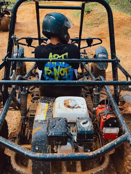 A close-up shot from behind a dirt kart, showing the powerful engine and rugged frame ready for the track.