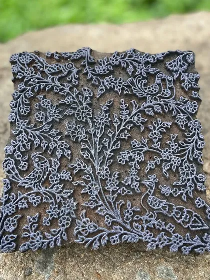This vintage 'tree of life' block is a treasured piece from our archive. Intricately carved with birds and flowers, it represents the deep connection to nature and heritage that we weave into every fabric we produce.