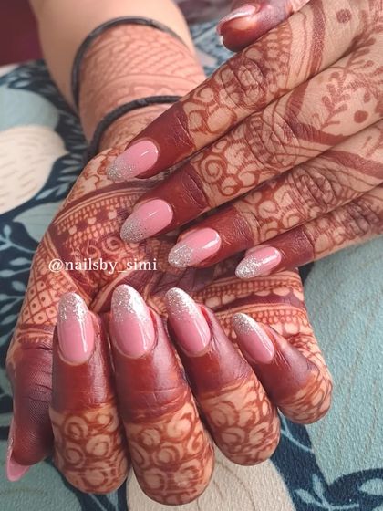 These glitter fall nails are perfect for a festive bridal look. The combination of a soft pink base with a silver glitter gradient looks absolutely stunning against the dark mehndi.
