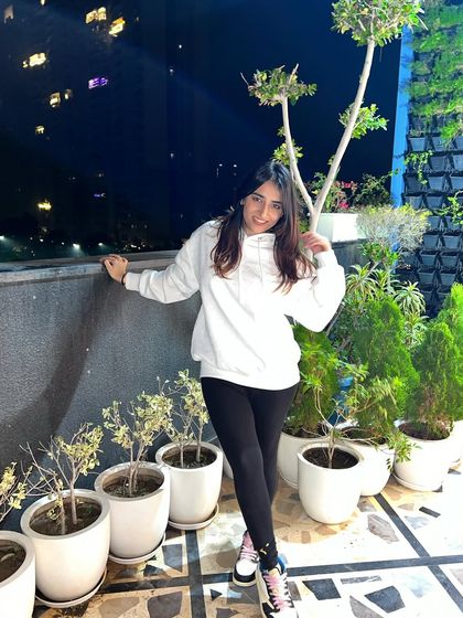 A cozy look in a white hoodie and black leggings on a rooftop at night. This is my go-to for a comfortable and stylish evening in.