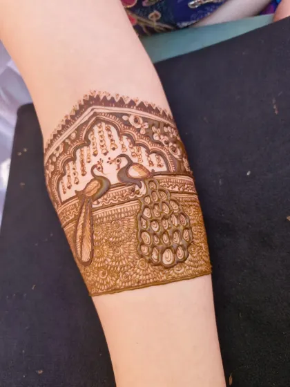 The other arm of the peacock armlet design, showing the beautiful symmetry and intricate detailing of the birds.