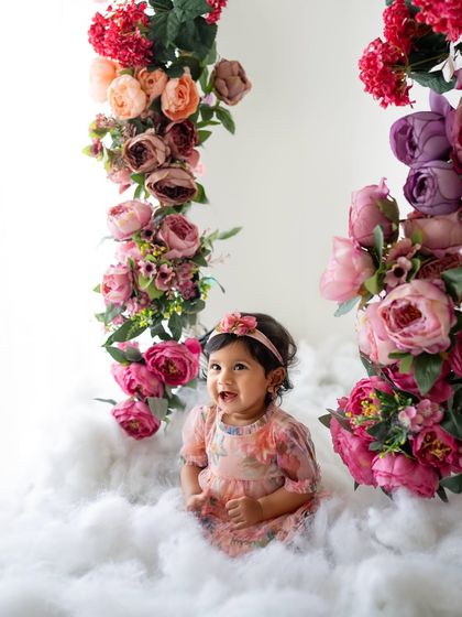 This little one is having the best time on her cloud. The different shades of pinks and purples in the flowers add so much depth.