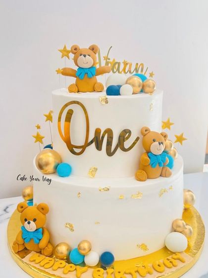 Twinkle, twinkle, little one. This two-tier teddy bear cake in white, blue, and gold is a classic and elegant choice for a first birthday.
