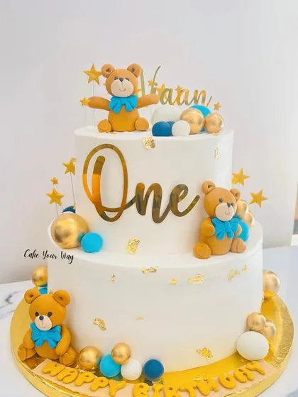Twinkle, twinkle, little one. This two-tier teddy bear cake in white, blue, and gold is a classic and elegant choice for a first birthday.