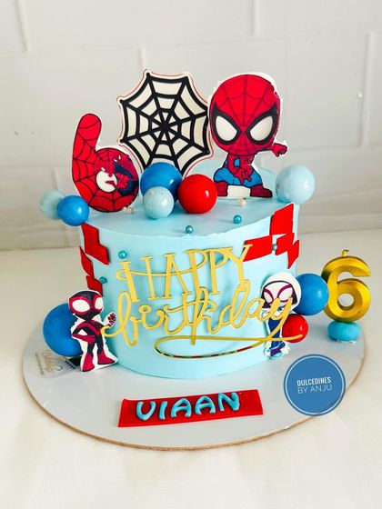 A bright and colorful Spider-Man cake with fun character toppers and balloon accents.