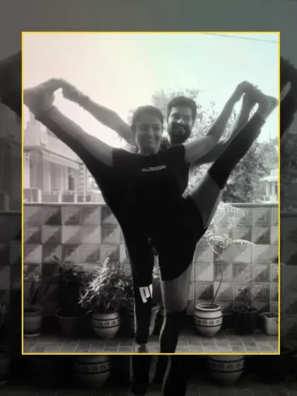 This standing acro yoga pose requires immense balance and flexibility from both partners, creating a symmetrical and powerful shape.