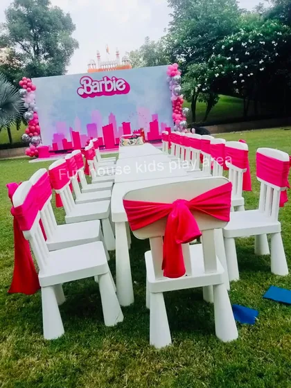 We bring your party themes to life. For this Barbie-themed birthday, we decorated our classic white chairs with bright pink sashes, perfectly matching the backdrop and creating an immersive experience for a truly memorable celebration.