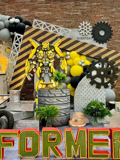 The 'TRANSFORMERS' marquee letters and Bumblebee prop create an exciting photo opportunity area.