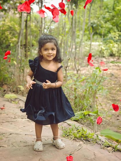 This little girl's sweet smile is perfectly captured amidst the falling petals. These action shots create dynamic and lively portraits.