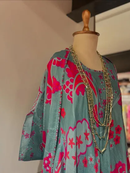 Embracing summer with florals. This printed kaftan in teal and pink is paired with a layered gold necklace for a relaxed, bohemian vibe.