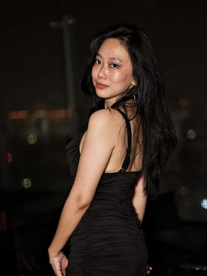 A guest posing against the stunning backdrop of the city skyline at night.