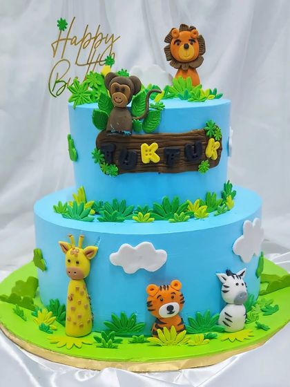 A two-tier jungle cake for Tuktuk's first birthday. We invited all her jungle friends, like the monkey, lion, and zebra, to celebrate on this yummy, freshly baked cake.