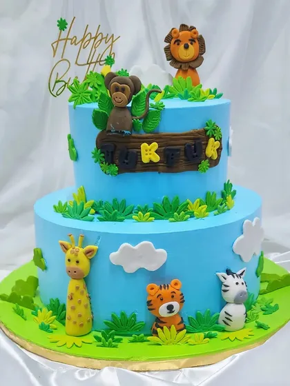 A two-tier jungle cake for Tuktuk's first birthday. We invited all her jungle friends, like the monkey, lion, and zebra, to celebrate on this yummy, freshly baked cake.