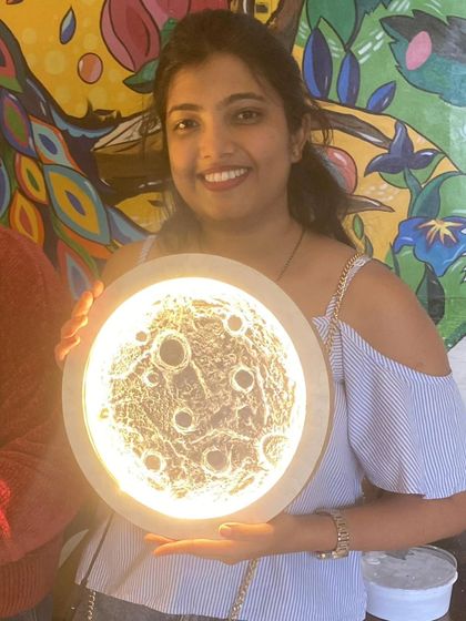 A close-up of a beautifully finished moon lamp, showcasing the detailed texture work that gives it a realistic lunar surface effect.