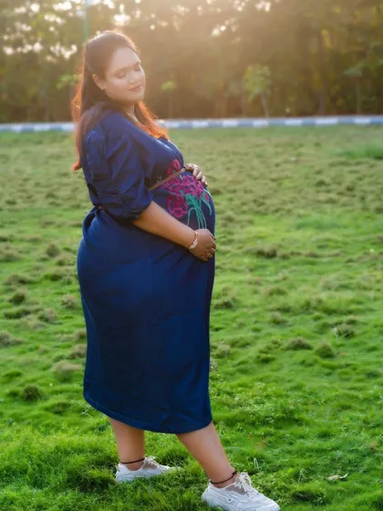 An outdoor maternity portrait taken during the golden hour. The warm sunlight and natural surroundings create a serene and beautiful atmosphere.
