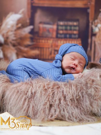 A full-body shot of the newborn in the rustic library setup. This pose shows off just how tiny and new they are.
