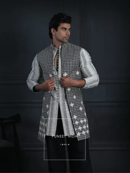 A monochrome Achkan that embodies modern craftsmanship. The intricate geometric weave, streamlined straight cut, and classic mandarin collar create a look of timeless poise for the contemporary man.