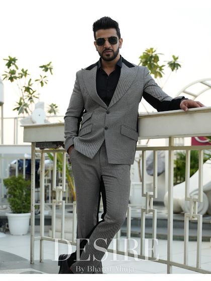 This full-length shot shows the complete grey and black suit, a perfect example of modern power dressing.