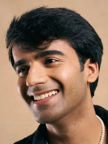 A bright, smiling shot that shows off the clean, natural-looking skin and the classic hairstyle.
