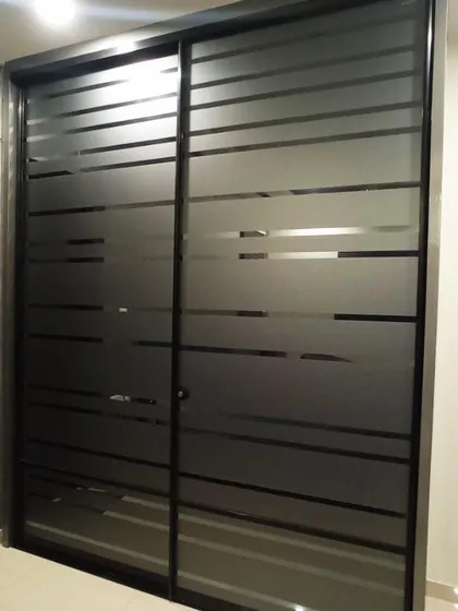 A modern Aristo wardrobe with frosted glass sliding doors. The horizontal stripes create a sleek, contemporary look while providing ample and easily accessible storage.