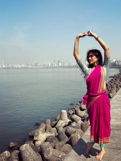Striking a dance pose against the Mumbai skyline. This image combines the urban landscape with traditional attire, creating a powerful fusion of classic and modern India.