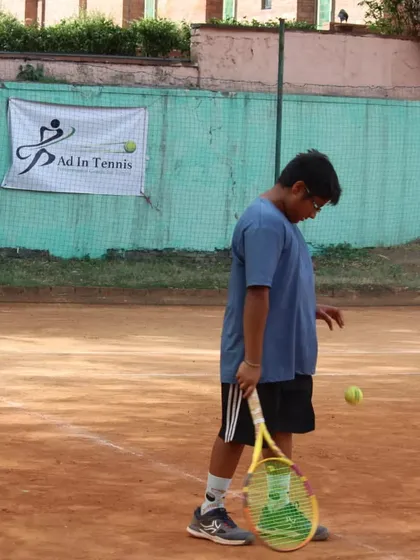 A player getting ready to hit a serve, focusing on the ball toss and preparation.