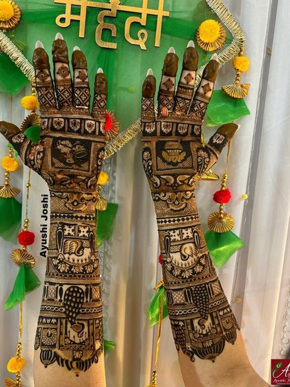 A beautiful shot of a full bridal mehendi set against a festive backdrop, showcasing the intricate details of the elephants and peacocks.
