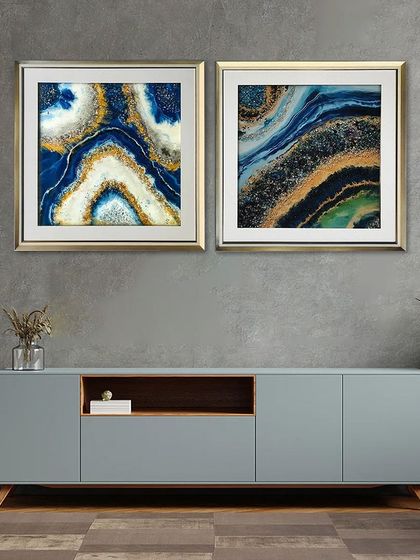 This pair of square resin art paintings features a stunning abstract design in deep blue and gold, resembling a cross-section of a geode. They are perfect for adding a pop of color and luxury.