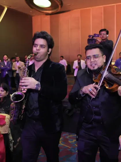 A customized musician flashmob in action, surprising guests at a corporate awards function. Here, a saxophonist and violinist move through the audience, creating an intimate and interactive musical experience.