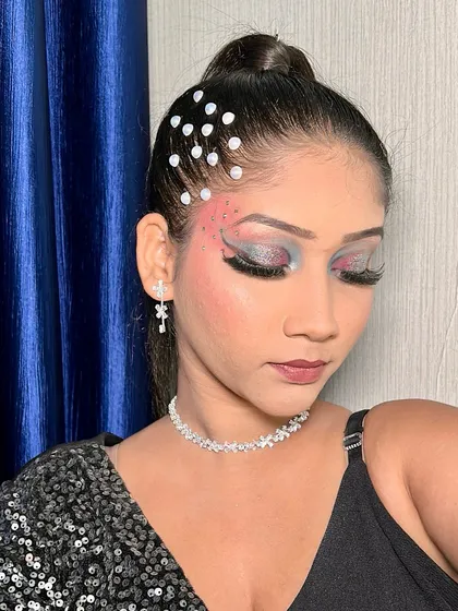 Another angle of the bold eye makeup, showing the artistic placement of pearls in the hair.