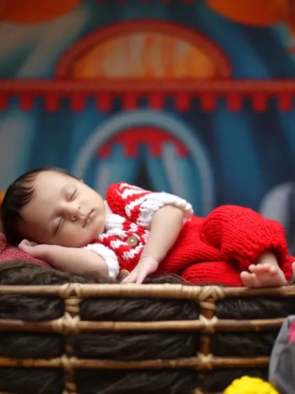 Welcome to the circus. This colorful theme features a classic circus tent backdrop and plush animals, with the baby sleeping peacefully in a basket.