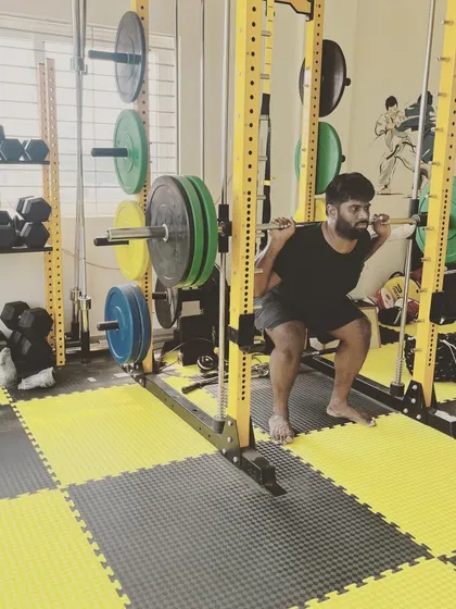 Building a strong foundation is key. Here, a member performs a heavy barbell back squat in our fully equipped strength area, focusing on proper form to build serious lower body power.