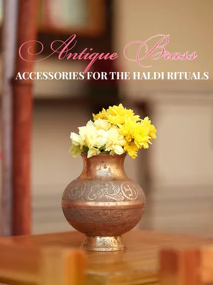 An antique brass pot used as a flower vase. Incorporating traditional accessories like these adds a layer of sophistication and nostalgia to the decor.