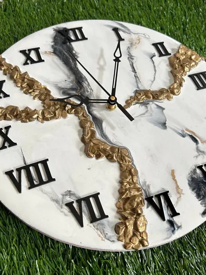 A unique take on the marble design, this clock features interesting patterns in black, white, and gold.