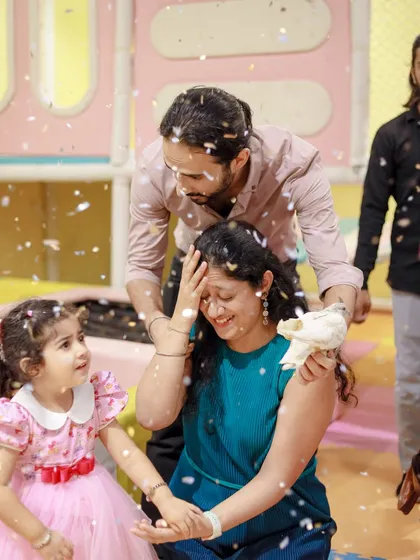 A family shares a laugh during a confetti shower at the magic show. We aim to create moments of joy that involve the whole family.