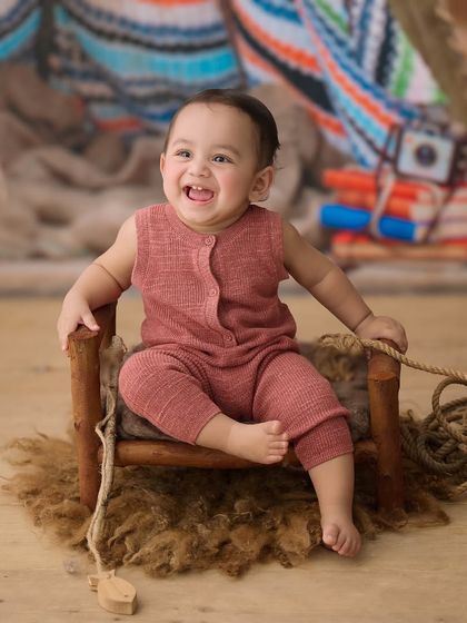 This little camper is all smiles. The rustic props and textures in this setup create a warm and adventurous outdoor feel.