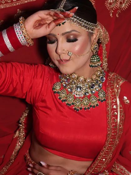 This image captures the soft, romantic side of a bridal look. With eyes gently closed, you can appreciate the smooth blending of the eyeshadow and the flawless, airbrushed finish on the skin.