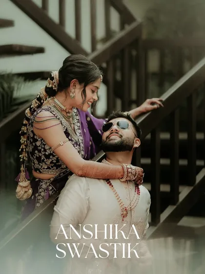 A stylish and modern couple portrait. The bride drapes her arm around the groom, both looking cool and confident, with clean text overlay adding a magazine-like quality.