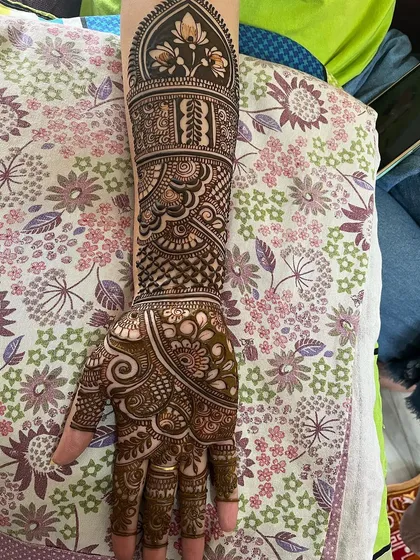 A single-arm view of a complete bridal design. This showcases the beautiful dome motif at the top, filled with floral patterns, and the various textures flowing down to the hand.
