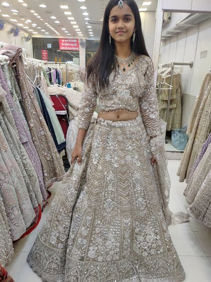 A still photo of the young client in the beige rental lehenga.