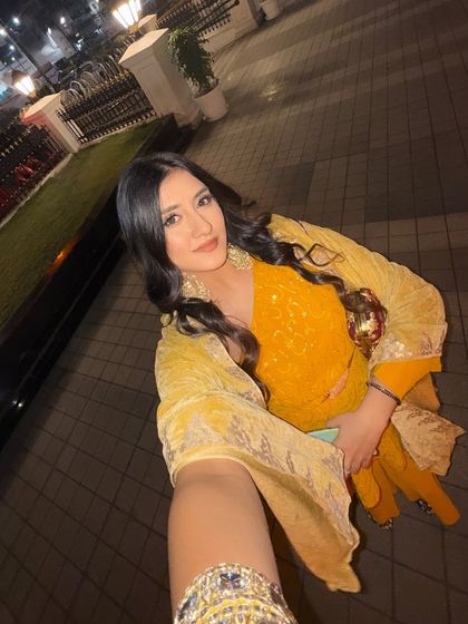 A full-length selfie showing off the entire yellow suit with a matching dupatta and an embroidered clutch.