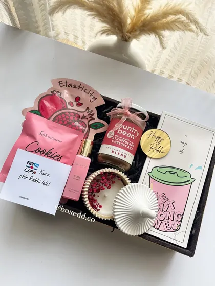 A perfect Rakhi hamper for a sister who loves to be pampered. It includes a planner, gourmet coffee, a scented candle, perfume, cookies, and a face mask.
