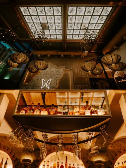 An atmospheric shot of the cocktail party venue, highlighting the stunning bar, chandeliers, and ambient lighting.