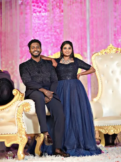 Posing for the camera, this couple shows how to coordinate in style. His black Jodhpuri and her navy gown are a perfect match for a grand reception.