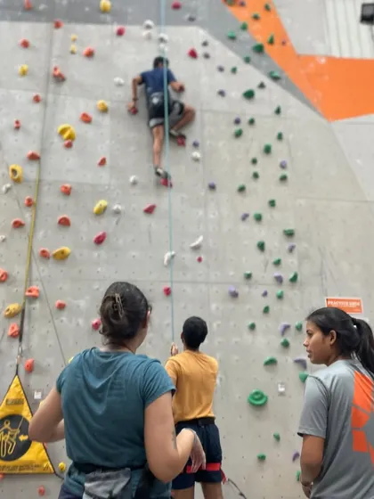 A group of friends watches and learns. Climbing is a great way to challenge yourself while having a great time with your crew.