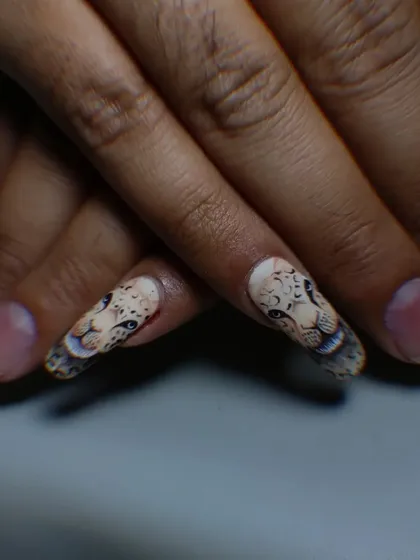 A close-up of a hand-painted leopard face, showcasing the fine brushwork and shading used to create a realistic effect.