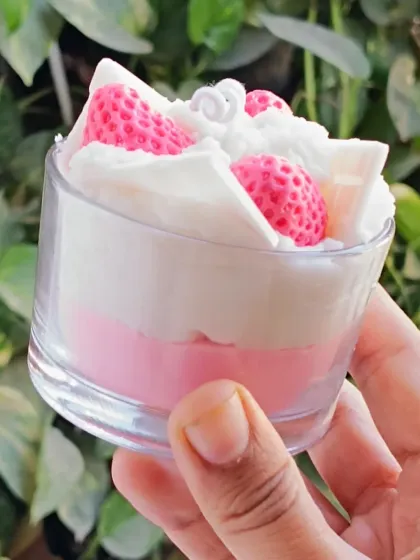 A side view of the strawberry ice cream candle, showing the distinct layers of color.