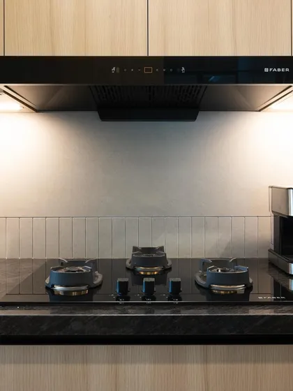 A close-up of the hob and the textured tile backsplash. Even in a minimalist design, small details like this add depth and interest.