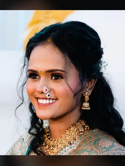 A beautiful portrait of bride Siddhi. The makeup focuses on enhancing her features with soft eye definition and a bright, happy lip color, perfect for her engagement day.