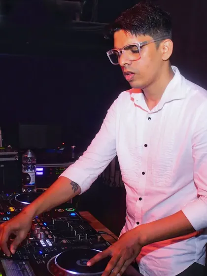 A clean, focused shot of me at the decks in a white shirt.